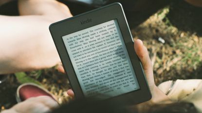 Best Kindles 2022: Image depicts person holding Kindle E-reader 