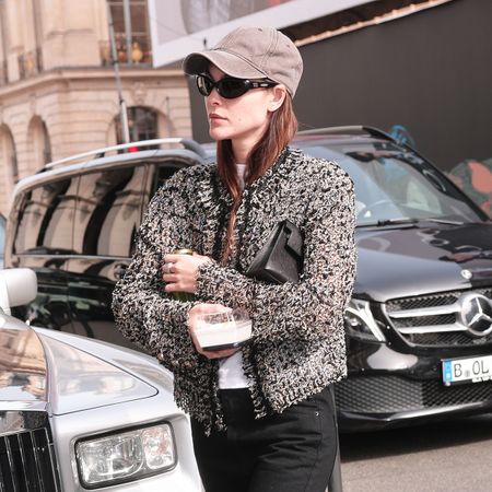 Vittoria Ceretti wearing a cardigan, baseball cap, black jeans, and tan suede flats in Paris
