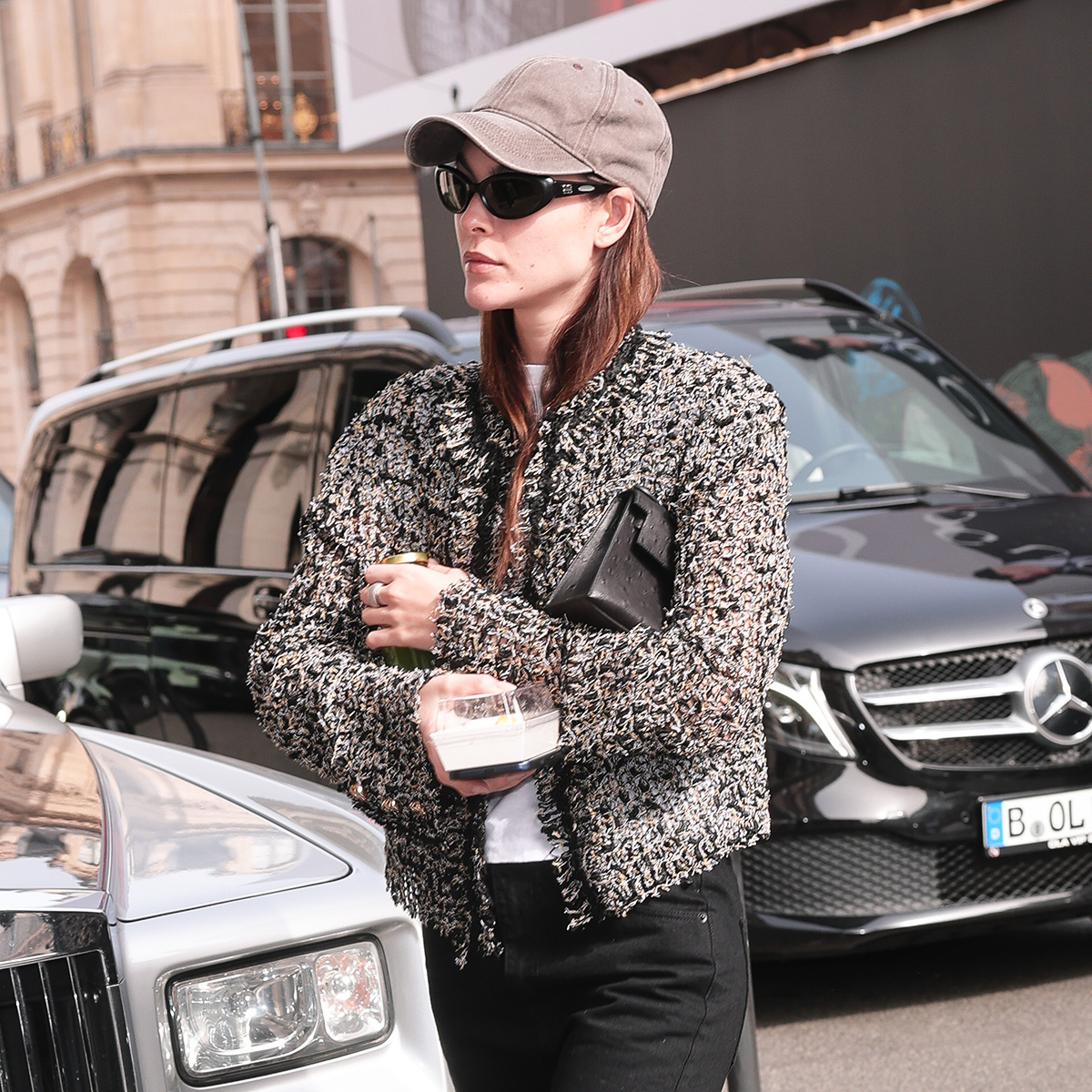 Vittoria Ceretti wearing a cardigan, baseball cap, black jeans, and tan suede flats in Paris