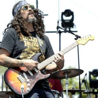 Brant Bjork playing a Fender Stratocaster an an outdoor stage