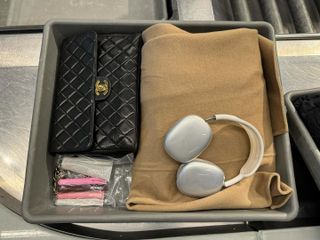 a Chanel flap bag, Rhode lip gloss and AirPods Max on the plane