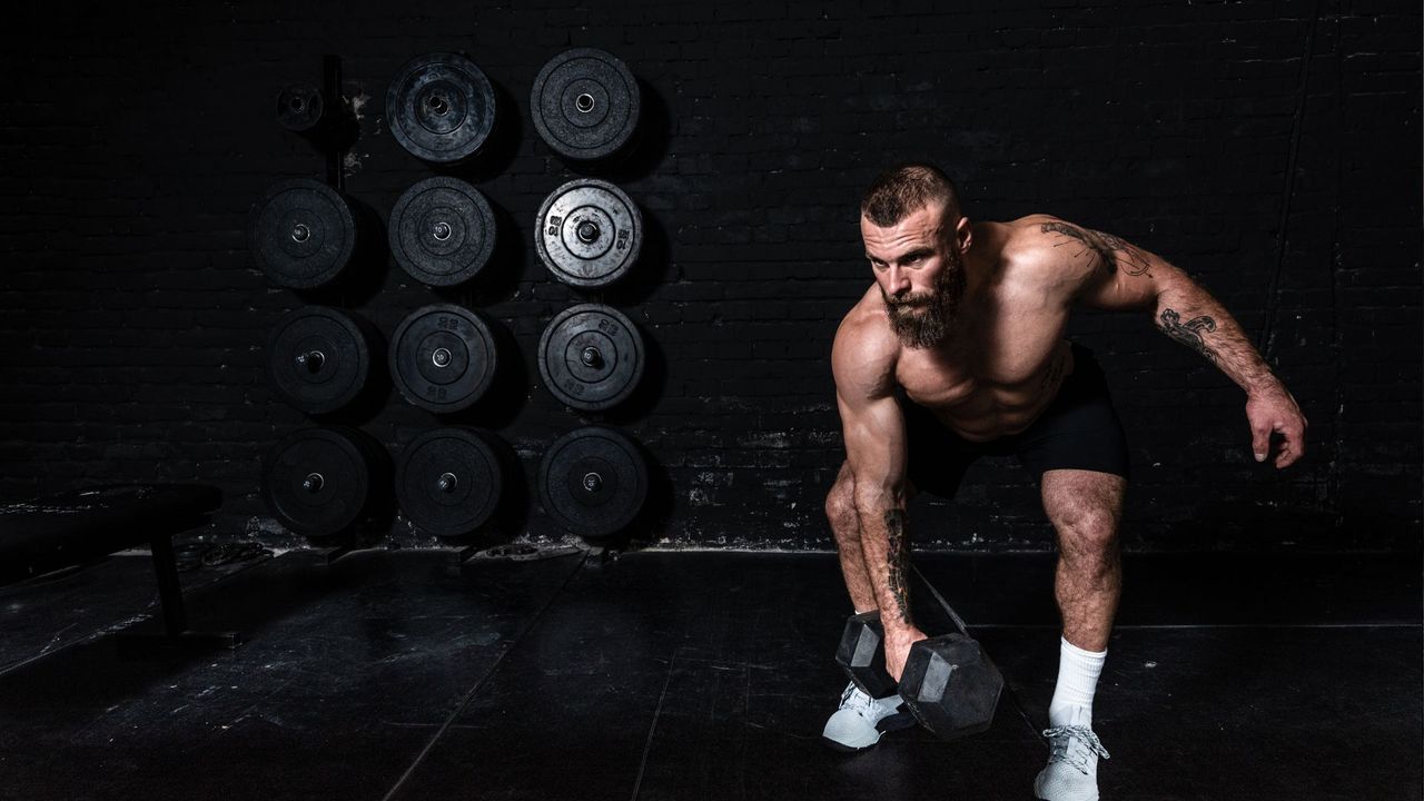 Man performing dumbbell snatch during AMRAP