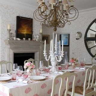 Dining room with pale patterned wallpaper and large chandelier