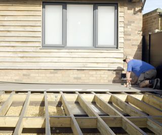 People attaching deck boards to deck frame