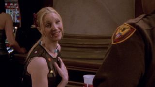 Phoebe leaning toward a guard while smiling in Friends