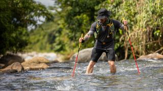 A runner crossing a river in the Jungle Amazonia