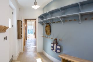 curved utility and boot room with blue wall