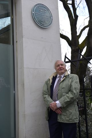 Sir David Attenborough pauses for a photo with the new plaque dedicated to William Smith.