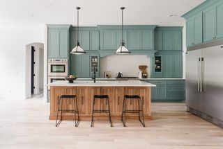 A kitchen with a blue green cabinet