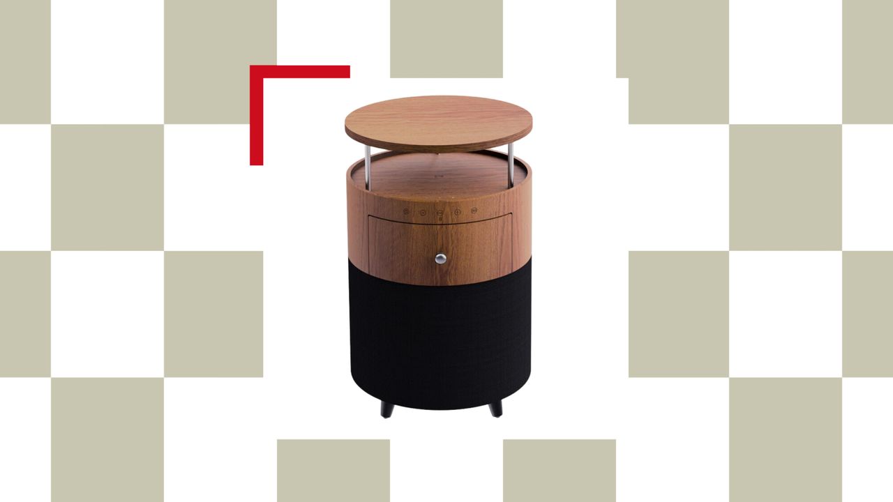 Sage green and white checkerboard background with a white product box in the center. In the product box is a cylinder-shaped wooden smart side table with a speaker built into the bottom