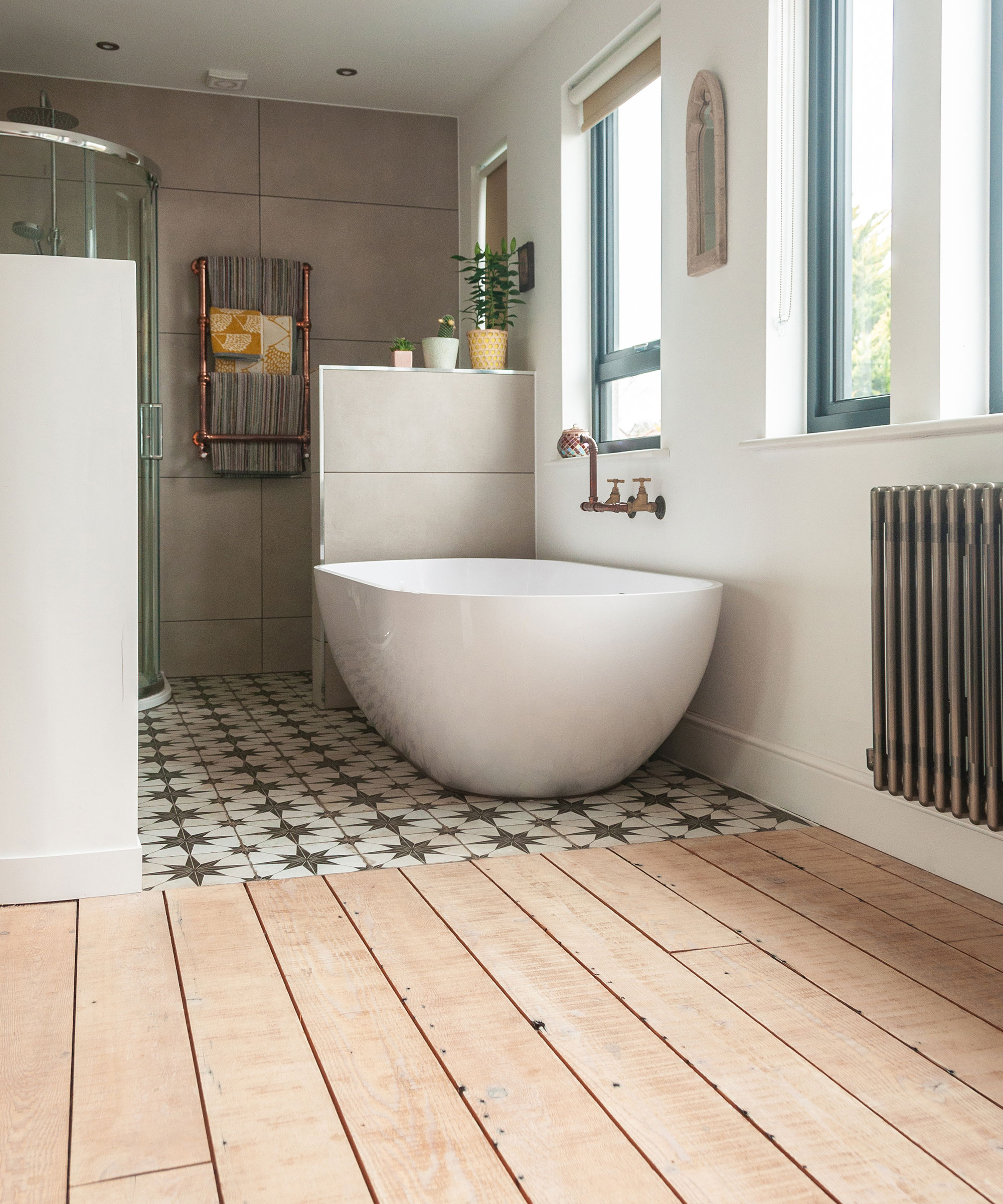 modern bathroom with half wooden flooring and freestanding bath