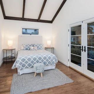 bedroom white wooden floor and white door and bed