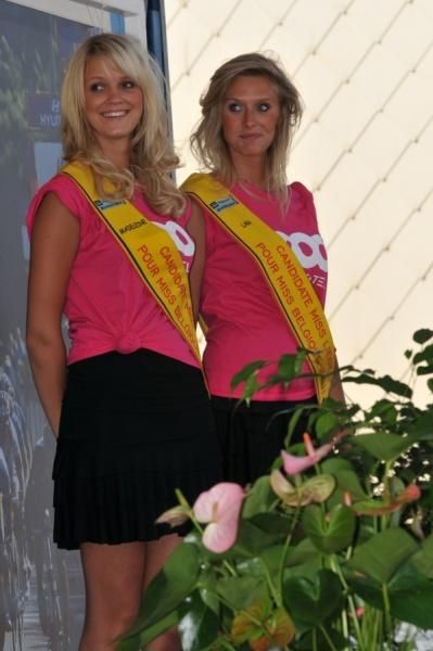 The podium girls smile as the winners enter stage right