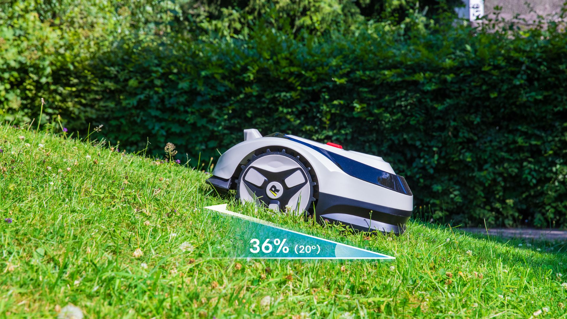 The RoboUP Raccoon 2 SE mowing on a slope. The slope is indicated as 36% or 20 degrees
