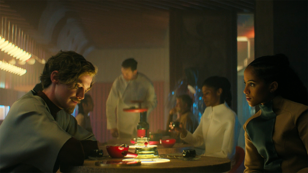 Brother Dawn and Gaal Dornick sitting at a cafe table in Foundation season 3 episode 3