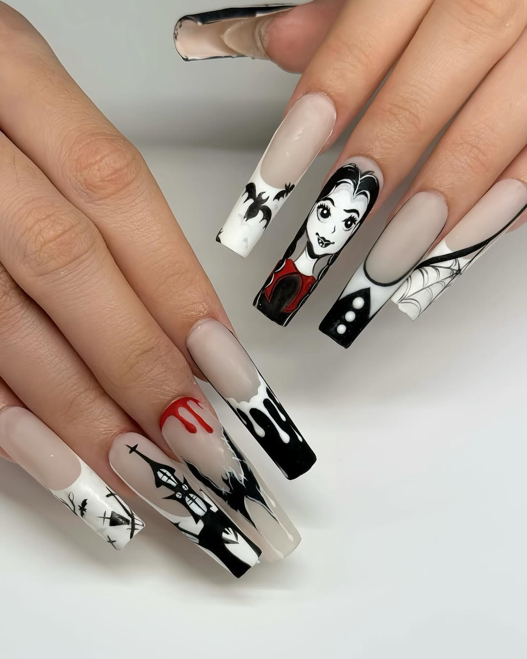 halloween manicure with red, black, and white designs