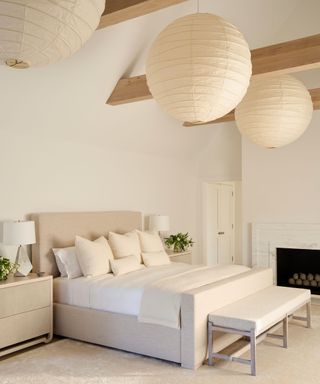 neutral scandi inspired bedroom with a large neutral, all white scheme and paper lantern ceiling lights