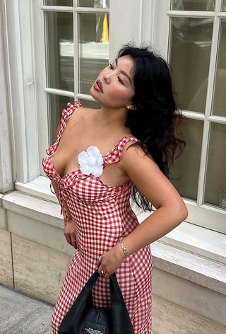 Allison Ho poses with windswept curls in a red gingham dress