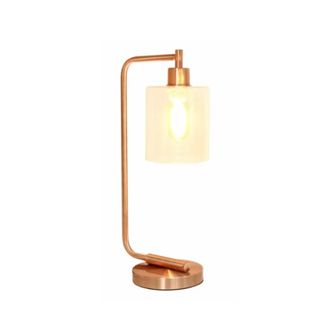 A rose gold metal desk lamp with cylindrical translucent shade