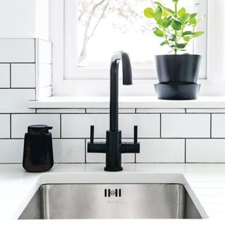 kitchen with white counter with sink and black tap