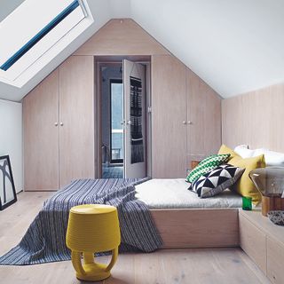attic bedroom with wooden floor and wardrobe