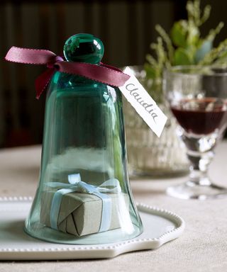 Christmas place setting with glass bell over small gift