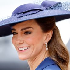 Princess Kate wearing a blue hat and smiling