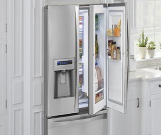 A kitchen with white painted cabniets and built-in fridge