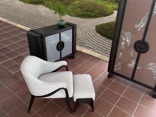 A living room space with furniture by Andre Fu, facing a traditional japanese zen garden with circular raked motifs