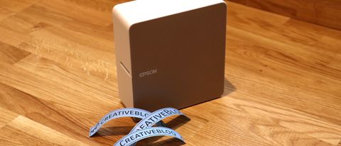 Epson LabelWorks LW-C610 review; a small brown printer on a wooden table with stickers