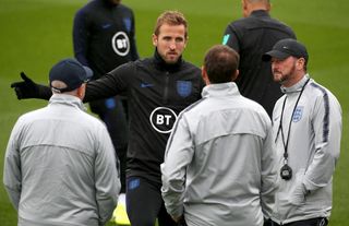 Harry Kane talks with manager Gareth Southgate and his staff