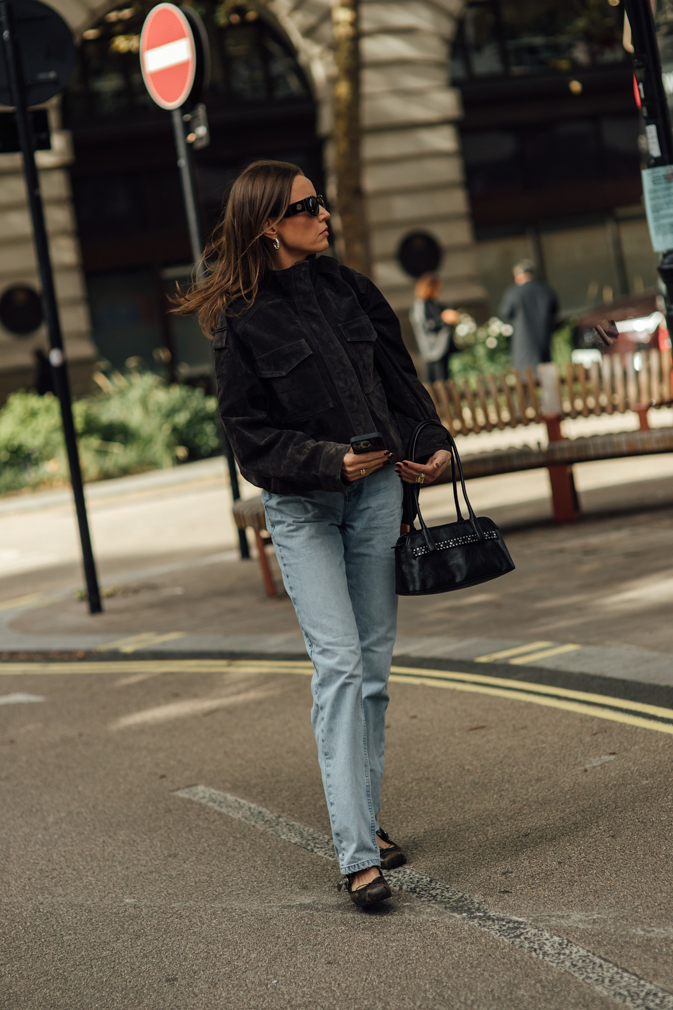 woman wearing stovetop jeans, suede jacket, and ballet flats