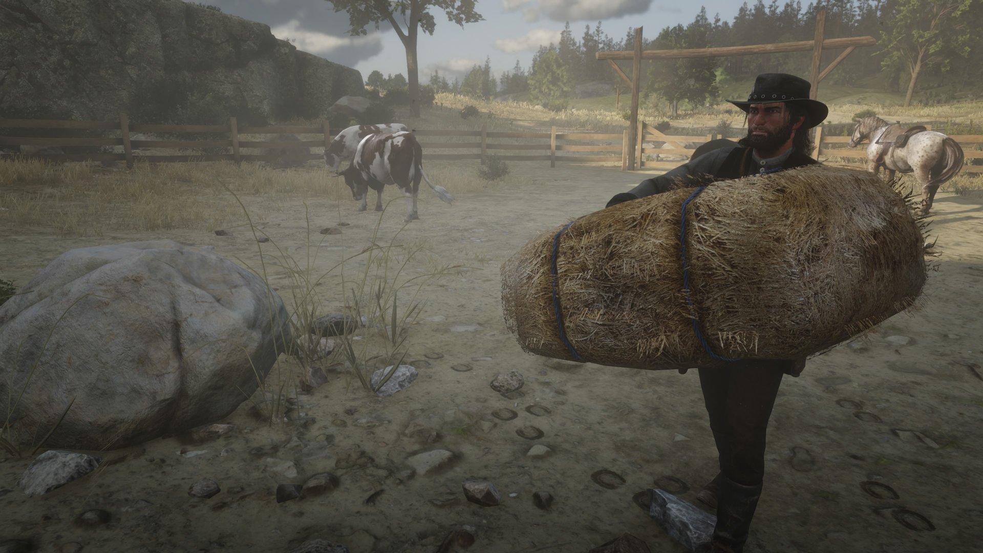 Red Dead Redemption 2 screenshot of John Marsten carring a bale of hay to a feeding point near some cows