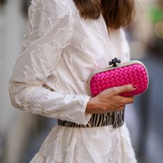 Therese Hellström wears a white gathered/pleated dress with embroidery and shoulder pads from H&M, a large black and white zebra print pattern belt, a Bottega Veneta pink bag and red jelly nails