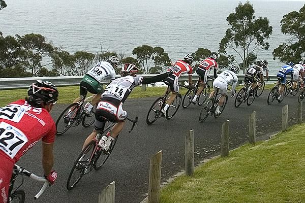 David Kemp (14) raises his team's 'Fly V' sign as he descends in the peloton.