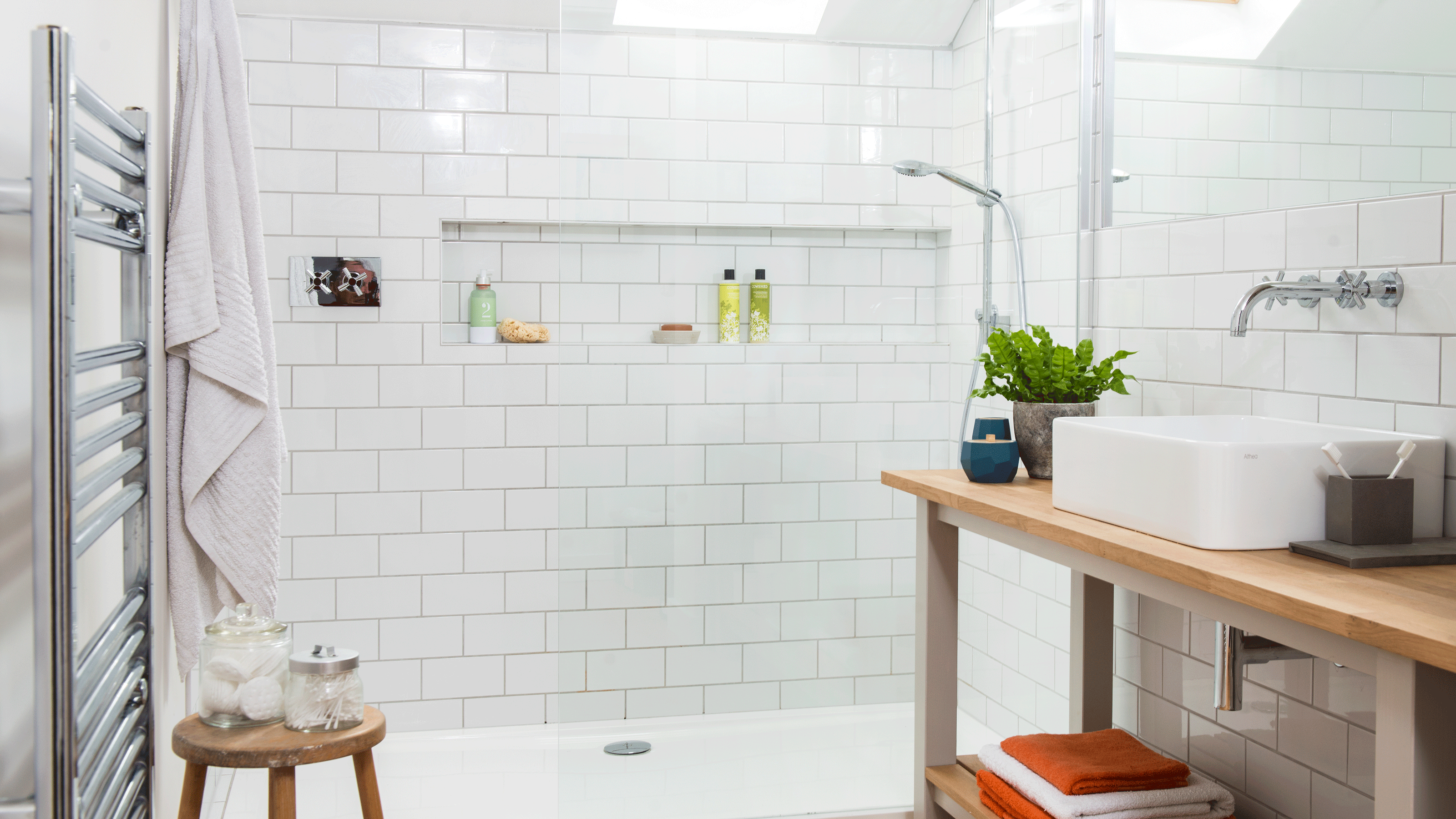 White bathroom with walk in shower and house plants