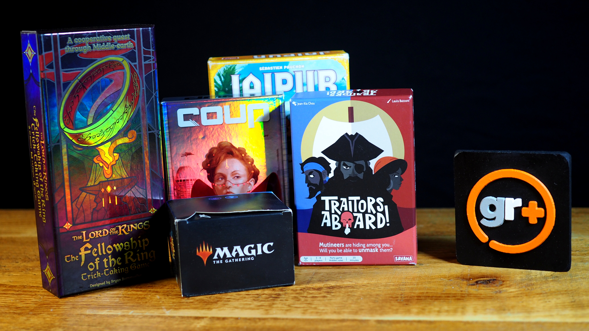 A selection of card games laid out on a wooden table, beside the GamesRadar+ logo
