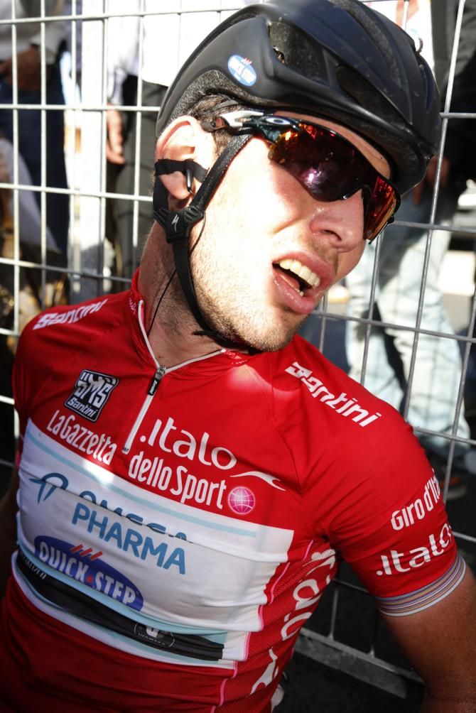 Cavendish slumps against a fence after his stage win