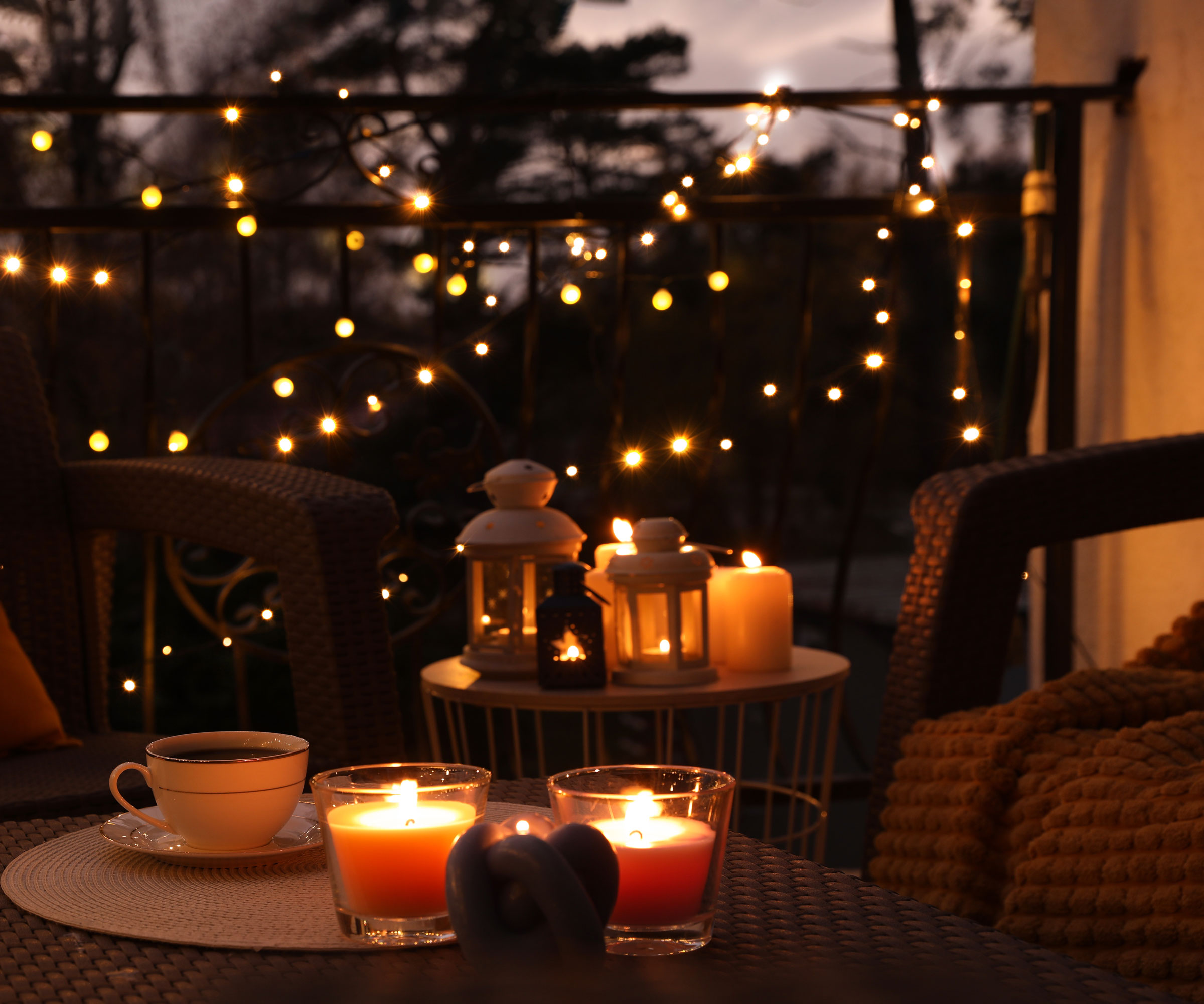balcony with table, chair, candles, lanterns, fairy lights and cup and saucer