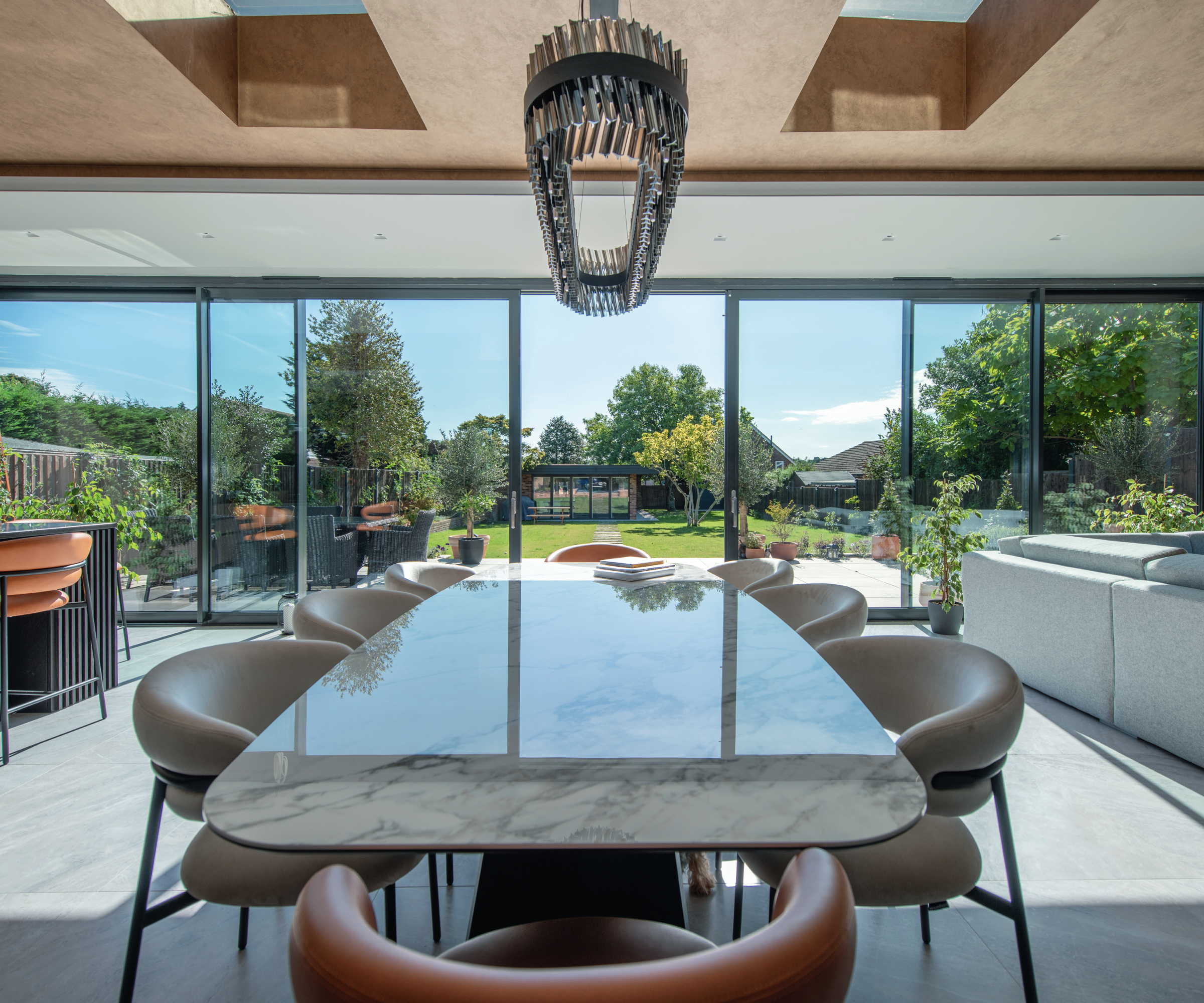 large expanse of sliding patio doors on modern extension with dining table centre of room