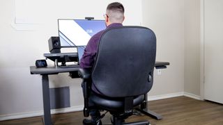 A person working in a BodyBilt Classic 2500 Series office chair at a desk