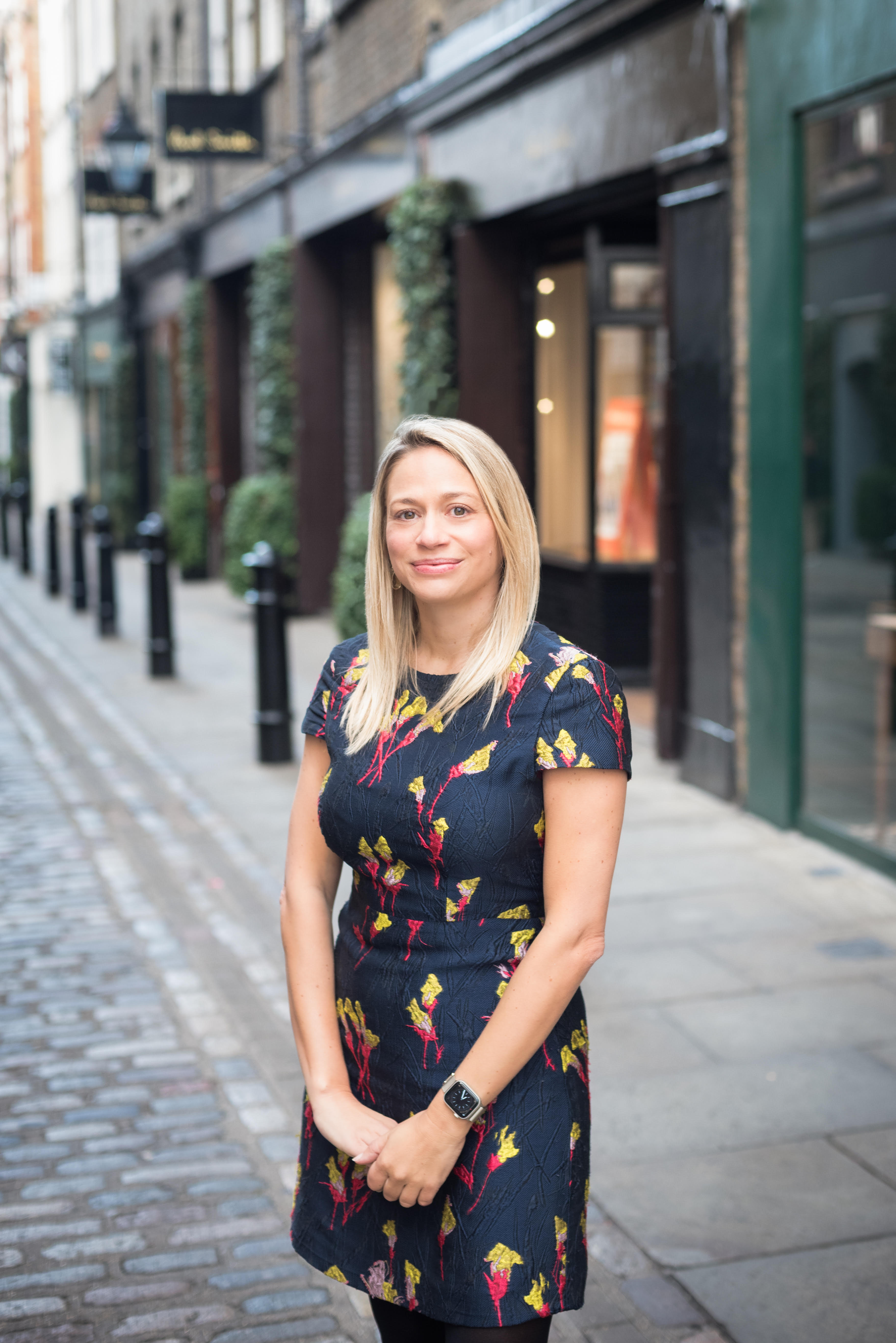 woman standing on a street smiling