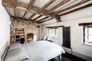 lime plaster in renovated bedroom with stone walls and exposed beams