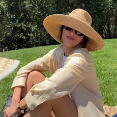 Kendall wears a straw hat, yellow shirt, and black pull-on boots.