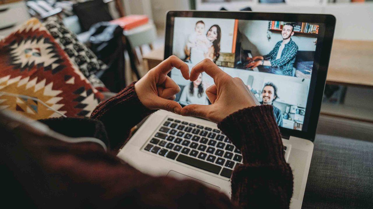 Person making heart with fingers while on a web camera call