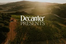Birds eye view of a vineyard on red soil with a tractor in the left of the image, and 'Decanter Presents' logo on top in white