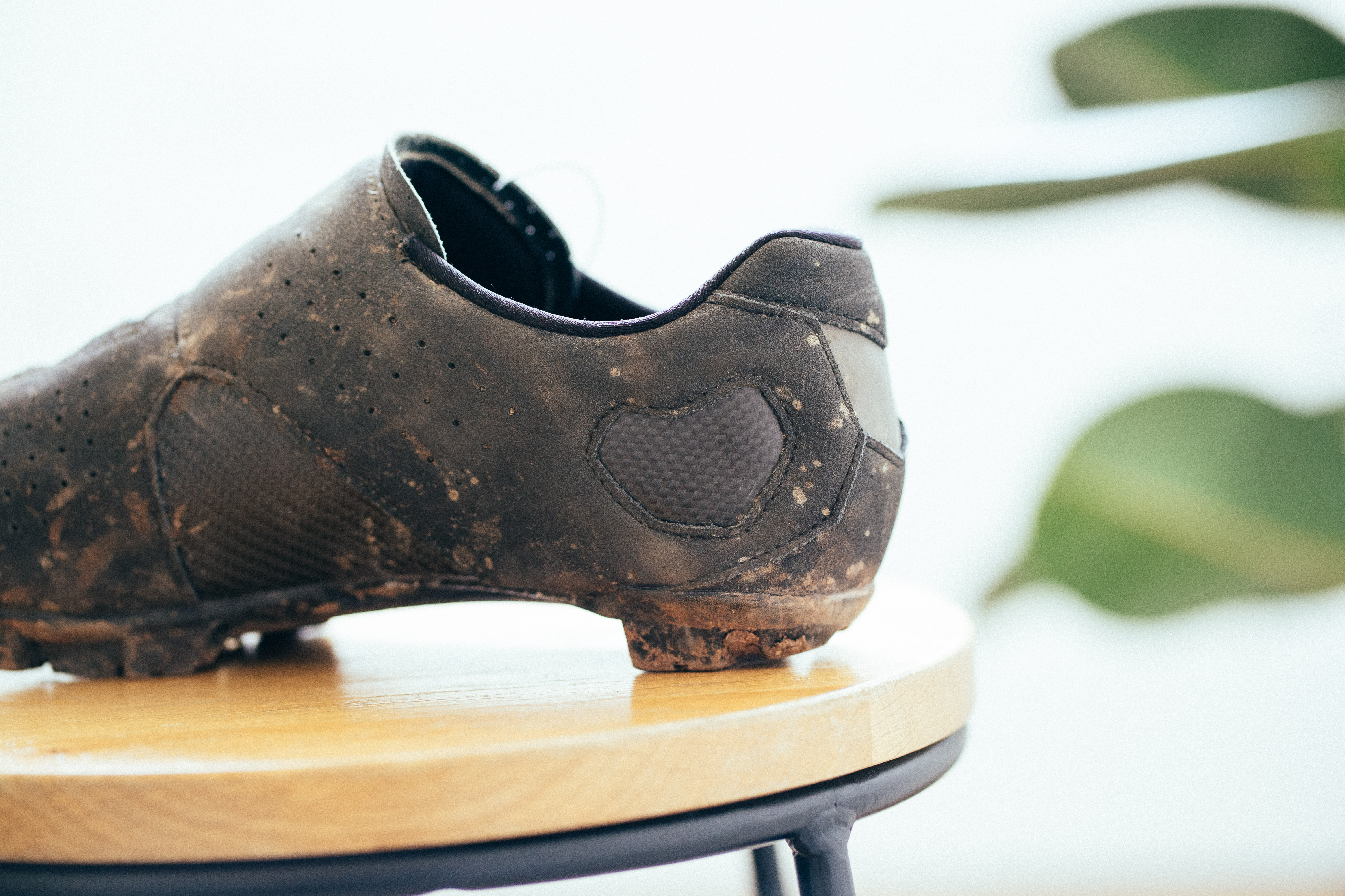 The heel of a black gravel shoe on a wooden stool