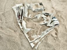 crumpled up newspaper under sand