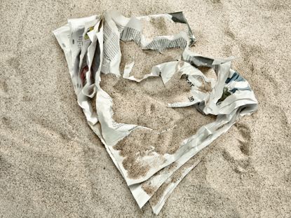 crumpled up newspaper under sand