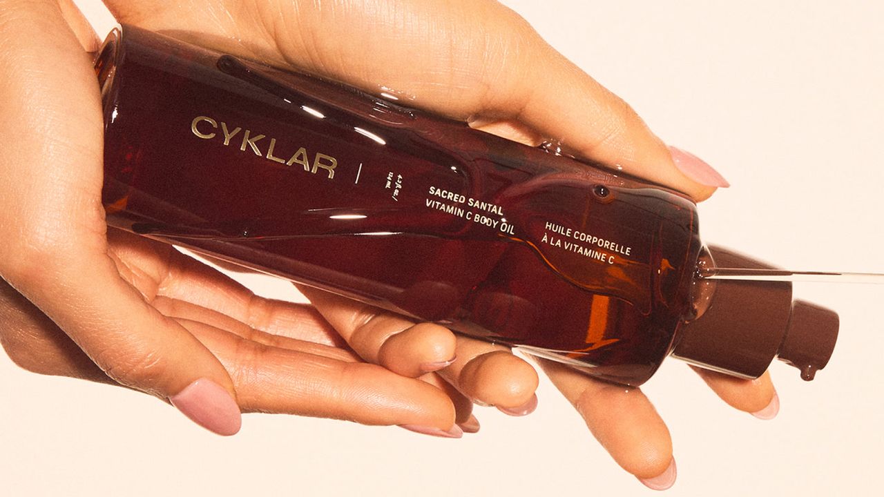 stylized image of hands holding cyklar vitamin c body oil 